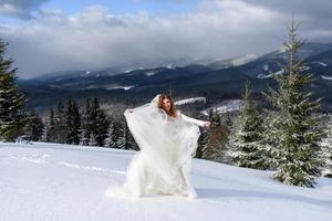 o noivo leva sua noiva pela mão para uma velha faia solitária. casamento de inverno. lugar para um logotipo. foto