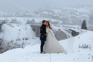 o noivo leva sua noiva pela mão para uma velha faia solitária. casamento de inverno. lugar para um logotipo.