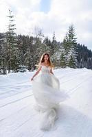 o noivo leva sua noiva pela mão para uma velha faia solitária. casamento de inverno. lugar para um logotipo. foto