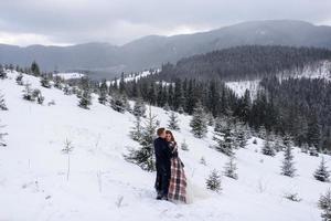 o noivo leva sua noiva pela mão para uma velha faia solitária. casamento de inverno. lugar para um logotipo. foto