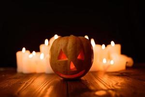 abóbora de halloween no fundo de velas e um fundo preto. foto