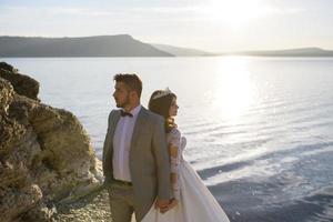 a noiva e o noivo estão andando perto do antigo castelo. o casal fica de costas um para o outro. foto