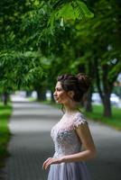 jovem e bela mulher posando em um vestido preto em um parque. foto