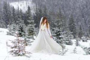 o noivo leva sua noiva pela mão para uma velha faia solitária. casamento de inverno. lugar para um logotipo. foto