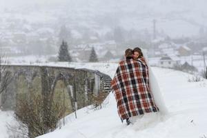 o noivo leva sua noiva pela mão para uma velha faia solitária. casamento de inverno. lugar para um logotipo. foto