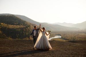 sessão de fotos de casamento dos noivos nas montanhas. sessão de fotos ao pôr do sol.