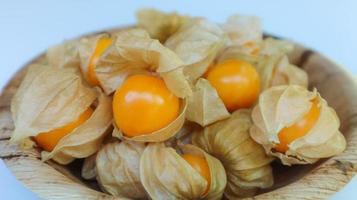 frutas orgânicas de groselha do cabo, physalis peruviana em placa de palma de betel foto