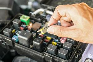 mecânico de automóveis, verificando um fusível de carro foto