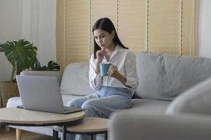 bela jovem fazendo videoconferência via computador em casa, conceito de tecnologia de negócios foto