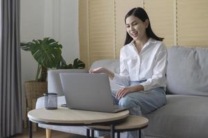 bela jovem fazendo videoconferência via computador em casa, conceito de tecnologia de negócios foto