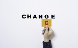 mão segurando o cartão amarelo com o alfabeto c para converter a mudança para a redação de chance em fundo branco para o conceito de pensamento de mentalidade positiva. foto