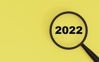 2022 ano novo dentro do vidro da lupa em fundo amarelo para foco no novo ano comercial e configuração do conceito de objetivo objetivo por renderização em 3d.