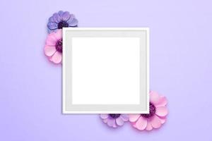 porta-retrato em branco rodeado de flores na superfície roxa. vista superior, composição plana leiga foto