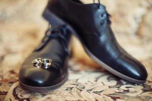 sapatos de homens negros e anéis de casamento foto