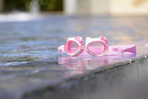 os óculos de natação são colocados ao lado da piscina. foto