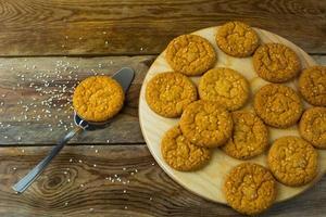 biscoitos de gergelim caseiro e espátula de bolo em fundo rústico foto