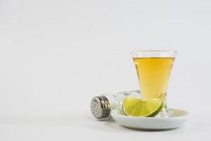 shot de tequila com limão e sal no fundo branco foto