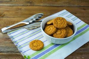 biscoitos de gergelim caseiro e pinças de bolo em fundo de madeira rústica foto