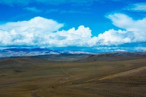 paisagem de estepe com uma estrada, montanhas, céu azul foto