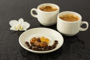 xícaras de café brancas e orquídea branca foto
