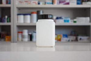 frasco de medicamento branco em branco com borrão prateleiras de drogas no fundo farmácia farmácia