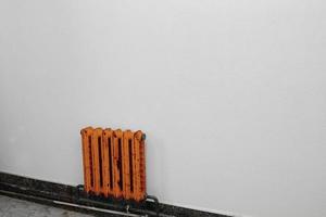 um radiador laranja contra uma parede cinza foto