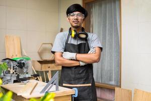 homem jovem carpinteiro confiante sorrindo em sua oficina foto