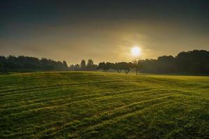 bela paisagem campo de golfe no nascer do sol da manhã foto