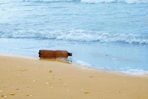 garrafa de plástico na praia, poluição do mar foto