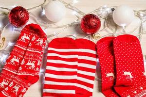 a meia colocada em uma mesa de madeira na sala de estar. conceito para a temporada de natal, bola vermelha e branca, luzes, brilhante, férias, ninguém, closeup foto