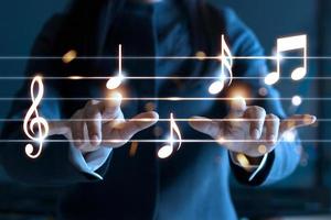 mãos de mulher tocando notas musicais em fundo escuro, conceito de música foto