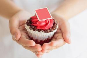 mão segure o cupcake dos namorados foto