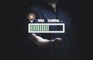 empresário segurando o ícone de download virtual com lâmpada para mostrar o progresso do status da ideia de pensamento criativo e conceito de resolução de problemas. foto