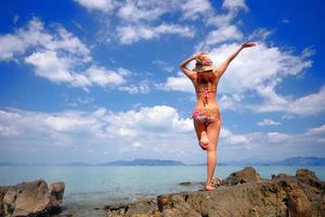 ação livre e relaxante de garota bronzeada de biquíni na praia de areia branca em krabi, tailândia. imagem do conceito para férias de verão no país tropical. foto