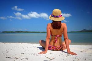 ação livre e relaxante de garota bronzeada de biquíni na praia de areia branca em krabi, tailândia. imagem do conceito para férias de verão no país tropical. foto