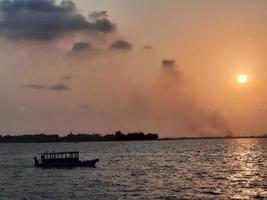 belo pôr do sol na praia masculina, maldivas foto