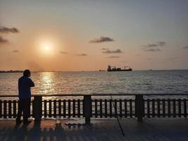 belo pôr do sol na praia masculina, maldivas foto