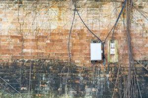 caixa de controle elétrico na velha parede de tijolos. foto