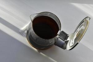 jarro de café de vidro com uma bebida em um fundo branco foto