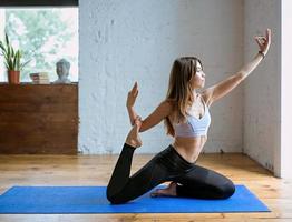 jovem apta em roupas esportivas em diferentes asanas de ioga indoor. conceito de ioga e esporte foto