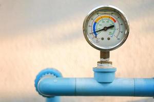 medidor de pressão de água no tubo de encanamento azul com fundo desfocado natural, espaço de cópia livre.