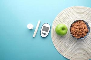 ferramentas de medição diabética, amêndoa e maçã na mesa foto