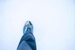 bota de caminhada pisando na neve virgem foto