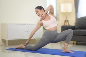 mulher apta fazendo ioga e meditação em casa, esporte e conceito de estilo de vida saudável. foto
