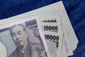 dinheiro japonês, notas de japão, ienes em fundo jean. foto