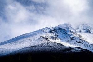feche o topo da montanha fuji com cobertura de neve e vento no topo com poderia no japão. foto