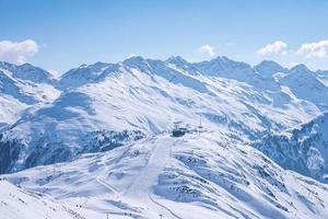 vista aérea de esquiadores e teleférico na encosta da montanha coberta de neve foto