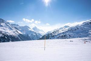 dia ensolarado em montanhas cobertas de neve nos Alpes foto