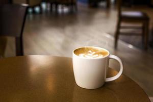 xícara de café quente com fumaça na mesa de madeira em vazio foto