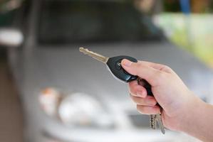 a mão das mulheres pressiona os sistemas de alarme de carro de controle remoto foto